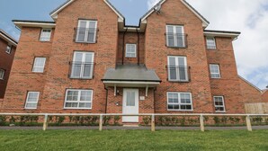 A two-story brick apartment building with a central entrance, multiple windows, and a small front garden. - Valley View (Whitby)