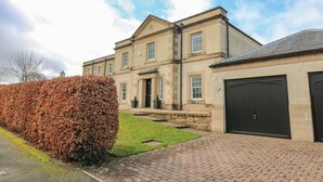 A large, two-story building with a symmetrical facade, a central entrance, and a garage. - 40 Bowmont Court (Kelso)