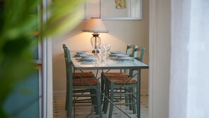 Een eettafel gedekt met borden, glazen en een lamp.