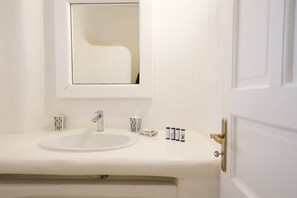 Bathroom features a sink, mirror, and toiletries.