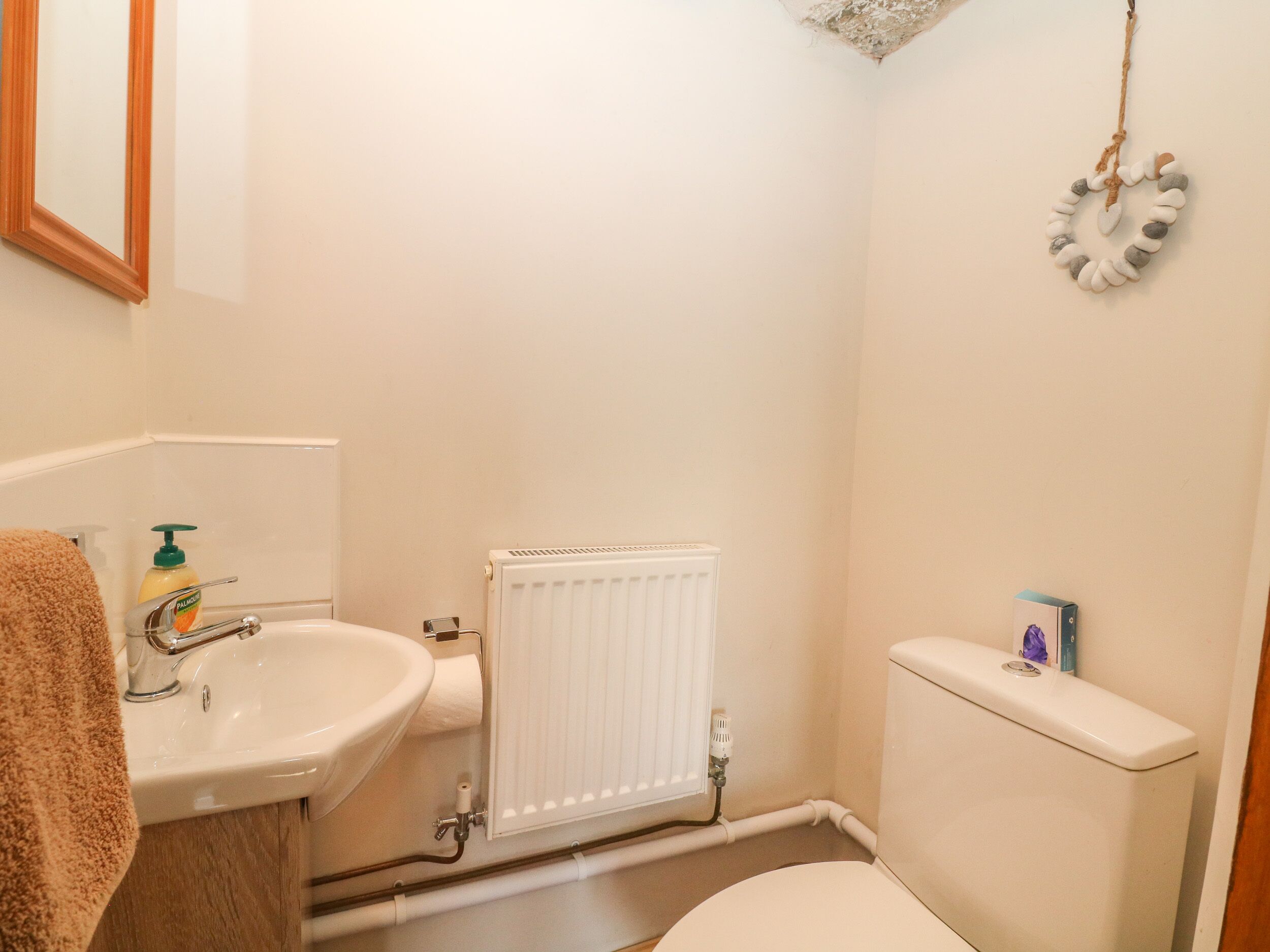 A small bathroom with a sink, toilet, and radiator.