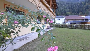 Un bâtiment à la façade en bois et un jardin agrémenté de rosiers roses.