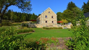 A stone house with a triangular roof, surrounded by a well-maintained lawn and trees. - Pet-friendly villa in Ondenval (Ondenval)