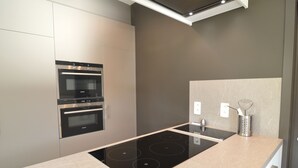 Una cocina moderna con horno empotrado, placa de cocción y salpicadero.
