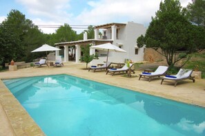 Relax by the serene pool surrounded by lush greenery and comfortable lounge chairs.