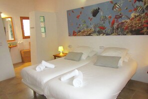 Relax in a serene space with a large bed, a beautiful painting of tropical fish, and a simple, clean design.
