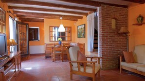 Una sala de estar acogedora con muebles de madera, chimenea y comedor con mesa y sillas.