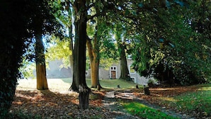 A pathway through a wooded area leading to a stone building with a door and windows. - Holiday Home in Verviers with Sauna & Fireplace (Ensival)