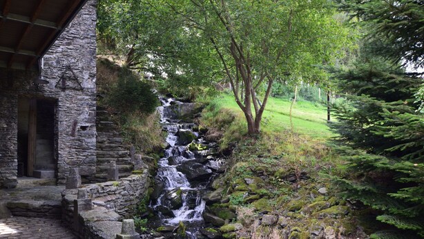 A stone building with a stone staircase leading to a wooden door. - Renovated Mill in Bastogne near Waterfall (Bastogne)