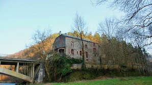 A stone building with a bridge in the foreground.
