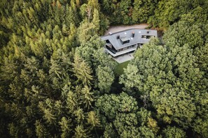 Ein modernes Haus, umgeben von dichtem Wald.