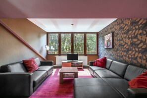 A modern living room with a sofa set, a coffee table, and a television.