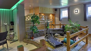 A room with a wooden floor, exercise equipment, a massage chair, and a small indoor garden. - Holiday Home in Stoumont near Coo Waterfalls (Rahier)