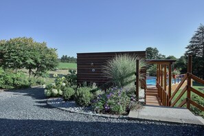 A wooden cabin with a gravel path leading to a wooden deck and a pool. - Holiday Home in Stoumont near Coo Waterfalls (Rahier)