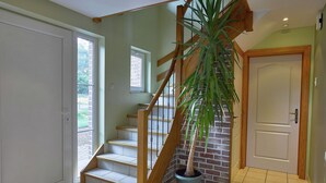 A staircase with wooden steps and a handrail, a potted plant, and a door with a handle. - Holiday Home in Stoumont near Coo Waterfalls (Rahier)