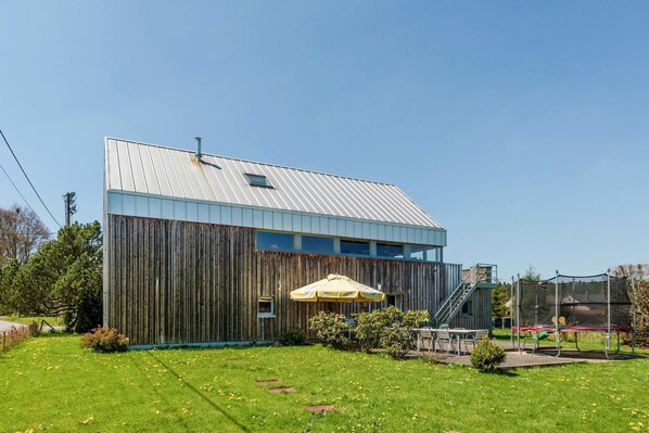 A modern building with a metal roof, wooden exterior, and a small window. - Comfy home near the forest with sauna (Waimes)