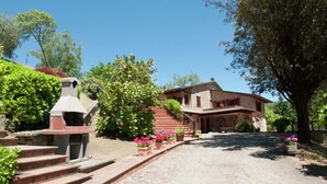 A stone staircase leading to a house with a tiled roof, surrounded by greenery and potted plants. - Villa in Casentino with Pool & Castle Views (Stia)