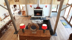 A cozy living room with a fireplace, wooden furniture, and a dining area.