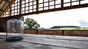A rustic wooden table with a clear glass jar and a metal container.