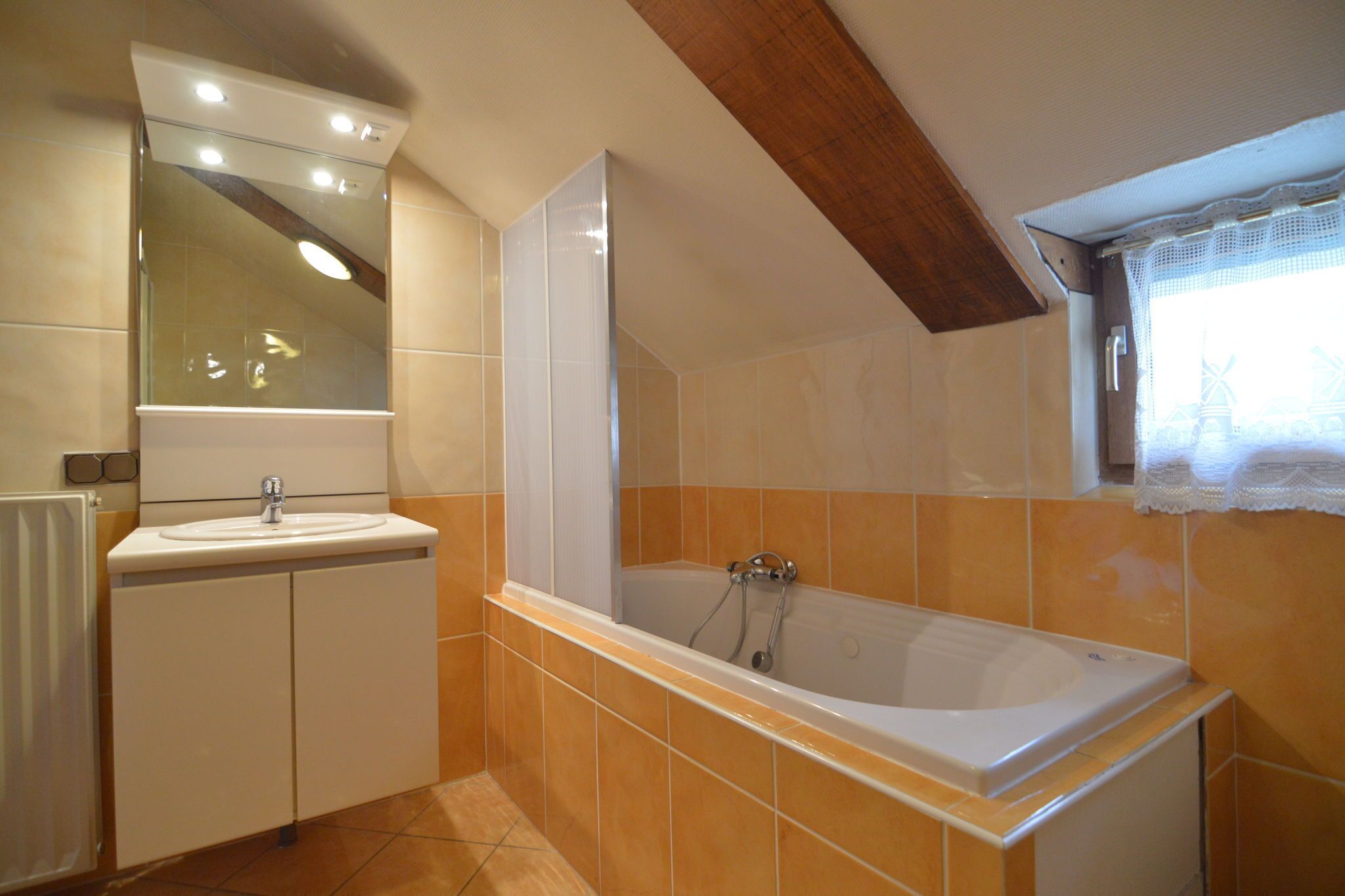 Een badkamer met een bad, een wastafel en een spiegel.