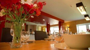A dining table with a vase of flowers, clear glasses, and a bowl. - Holiday Home in Stoumont near Spa Resort (Stoumont)