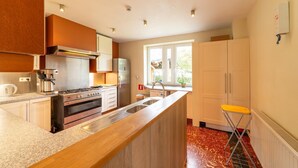 Een moderne keuken met roestvrijstalen apparatuur, houten kastjes en een groot raam voor natuurlijk licht.