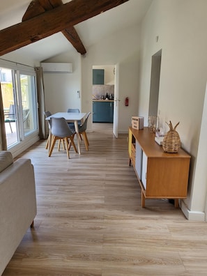 Enjoy meals in the dining area, which leads to a kitchen with a console table and sliding glass door to an outdoor space.