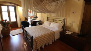 A bedroom with a bed, a desk, a chair, and a large window.