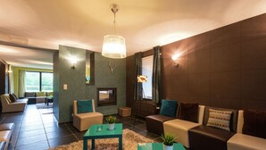 A modern living room with a sofa set, a coffee table, and a TV. - Swanky Holiday Home in Waimes with Indoor Swimming Pool (Waimes)