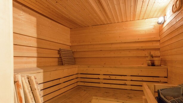 A wooden sauna with benches and a bench seat.