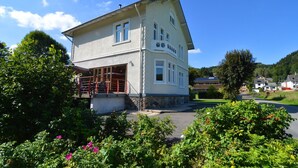 A two-story building with a balcony and a covered entrance.