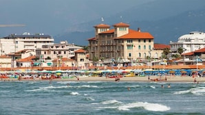 Une ville côtière dotée d’une plage, de bâtiments et bordée de montagnes.
