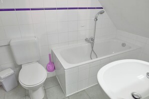 Une salle de bain comprenant des toilettes, une baignoire et un lavabo.