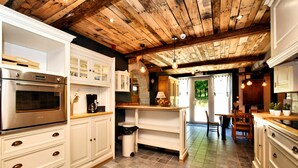 A kitchen with white cabinetry, a stainless steel oven, and a wooden ceiling. - Magnificent Holiday Home in Baronville with Heated Pool & Billiards (Beauraing Ardennes)