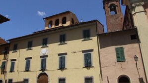 A multi-story building with a prominent clock tower and a bell. - Pisa Stay close to Leaning Tower (Pisa)