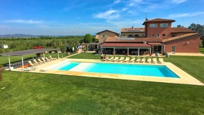 A large house with a swimming pool, a covered patio, and a well-maintained lawn. - Tuscan Stay w/ Jacuzzi (Braccagni)