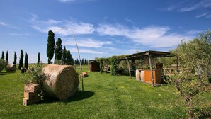 A rural outdoor setting with a large hay bale, wooden structures, and a pergola. - Tuscan Stay w/ Jacuzzi (Braccagni)