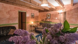 A cozy living room with a wooden ceiling, a sofa, a small table, and a lamp. - Cosy holiday home in Marsac with pool (Marsac)