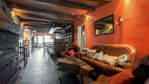 A cozy interior with a leather couch, a coffee table, and a bar area in the background. - Quaint Apartment in Sensenruth with Terrace (Sensenruth)