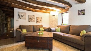 A cozy living room with a brown leather sofa, a wooden coffee table, and artwork on the walls. - Quaint Apartment in Sensenruth with Terrace (Sensenruth)