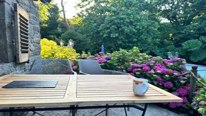 Puisesta pöydästä, jossa on metallijalat, on asetettu valkoinen muki ja musta esine.