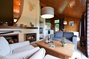 Una sala de estar acogedora con chimenea, un sofá, una mesa de centro y un comedor.