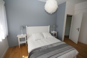 A bedroom with a bed, two bedside tables, a hanging light fixture, and a door leading to another room. - Luxurious Villa in Pont-Aven with Private Pool (Pont-Aven)