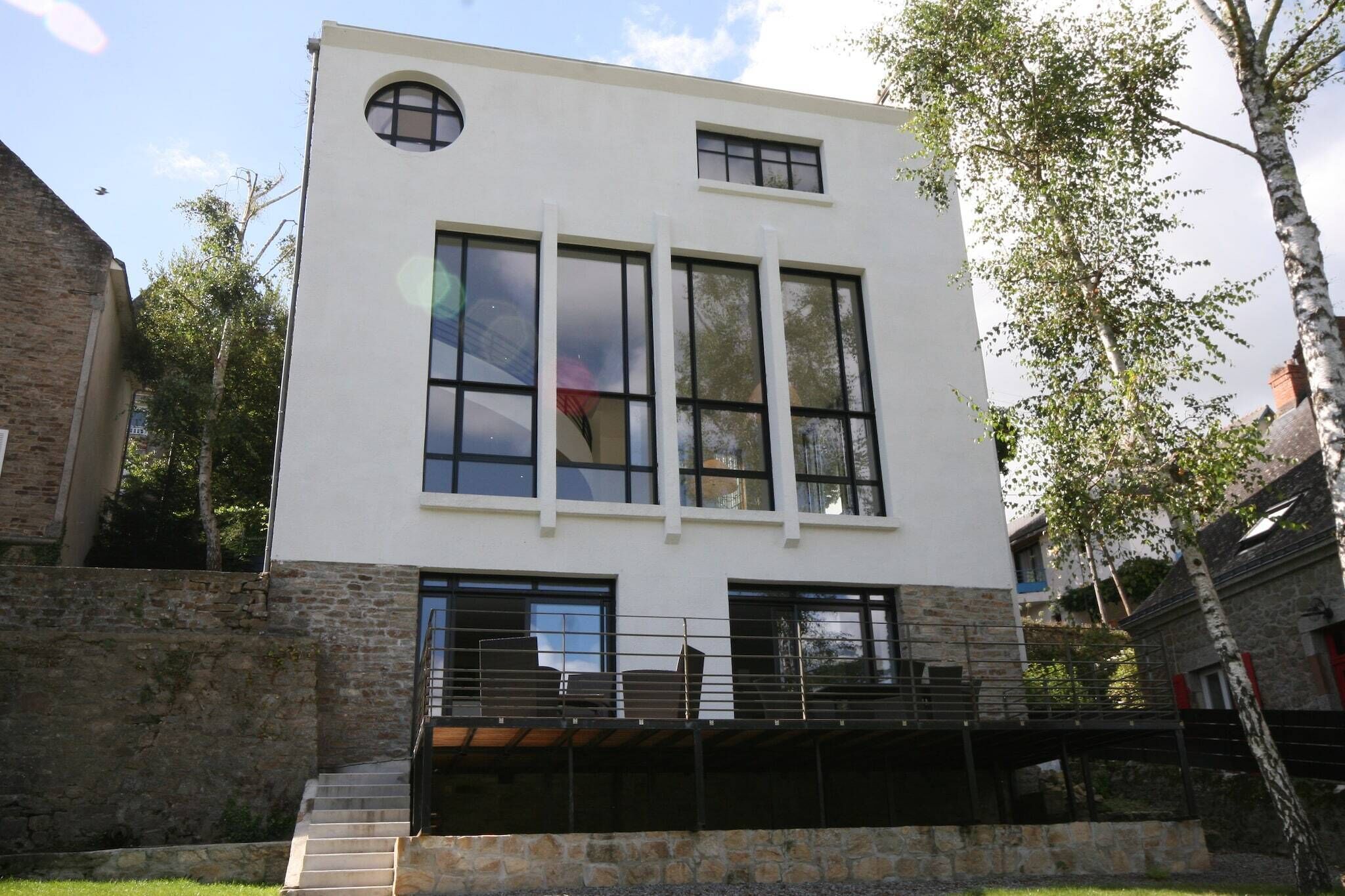 A modern two-story building with large windows and a stone facade.