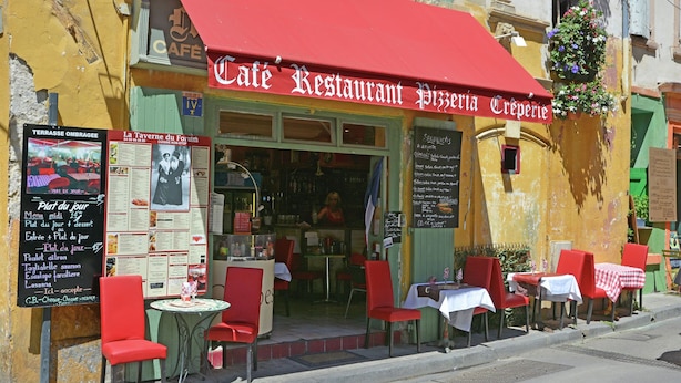 A café with outdoor seating, a red awning, and a menu board. - Villa in Bagard with Garden, BBQ, Garden Furniture, Playroom (Bagard)
