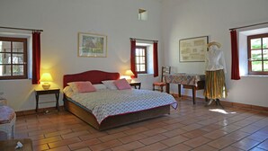 A bedroom with a bed, two bedside tables, a chair, a table, and a mannequin. - Villa in Bagard with Garden, BBQ, Garden Furniture, Playroom (Bagard)