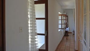 A hallway with a wooden door, a window with a wooden frame, and a tiled floor. - Villa in Bagard with Garden, BBQ, Garden Furniture, Playroom (Bagard)