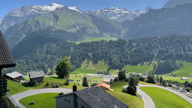 Un paysage de montagne avec un village, des routes et des bâtiments.