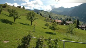 A rural landscape with rolling hills, scattered trees, and a few buildings in the distance. - Serene Farmhouse in Habkern with Parking (Habkern)