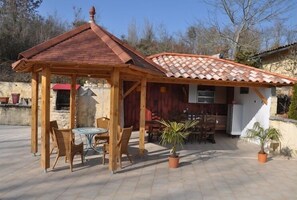 Relax in the serene outdoor patio, surrounded by lush greenery and a charming pergola.